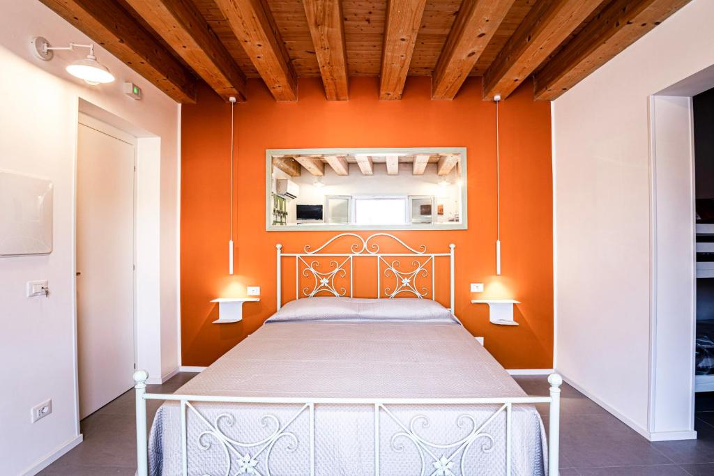 a bed in a room with an orange wall at Panormos91 Rooms&Terrace in Palermo