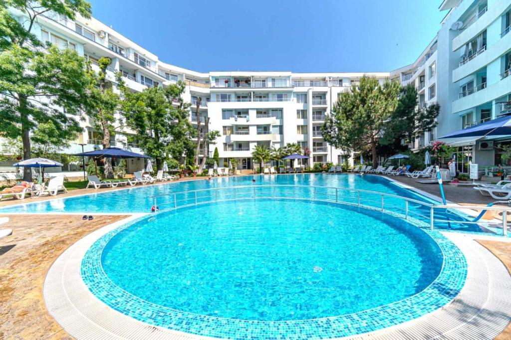a large swimming pool in front of a building at Yassen Holiday Village in Sunny Beach