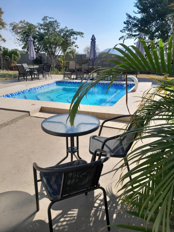 マンジニにあるThe Ridge BnBのプールの前のテーブルと椅子