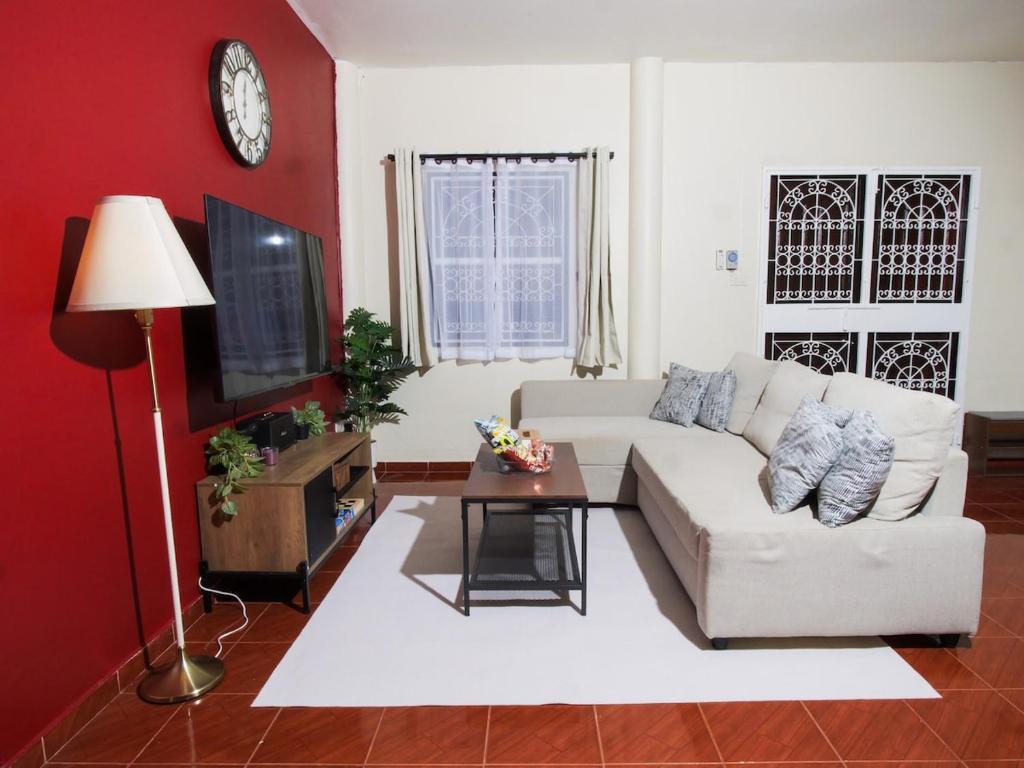 a living room with a white couch and a tv at Cozy House 2BR BTS Ekkamai in Bangkok