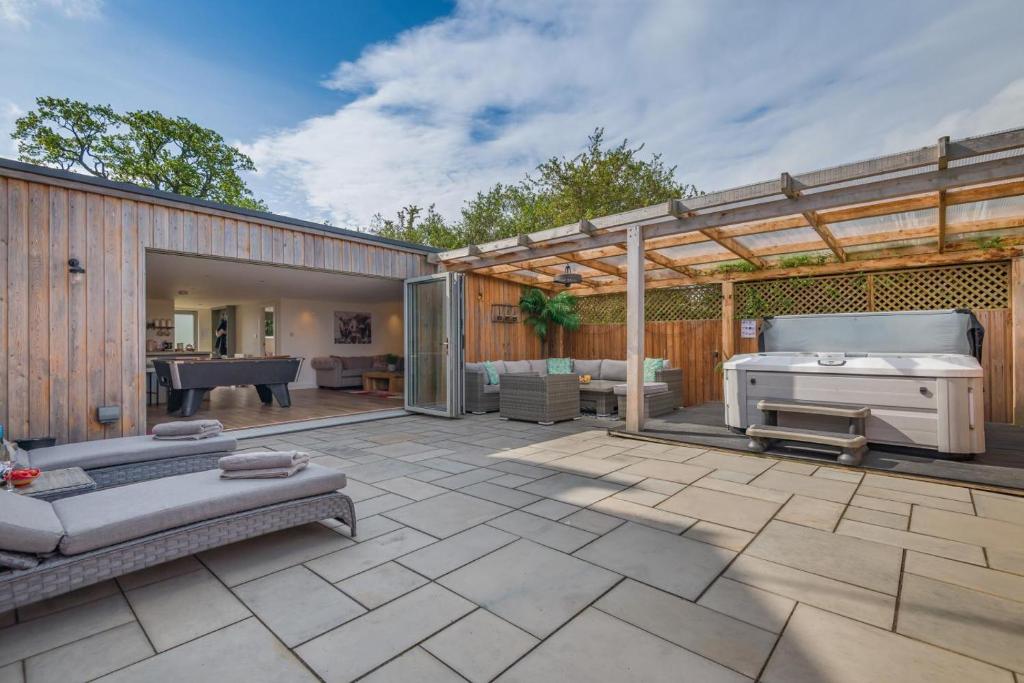 Un patio al aire libre con una cama y una parrilla. en Bluebell Farm - The Cabin, en Shurdington