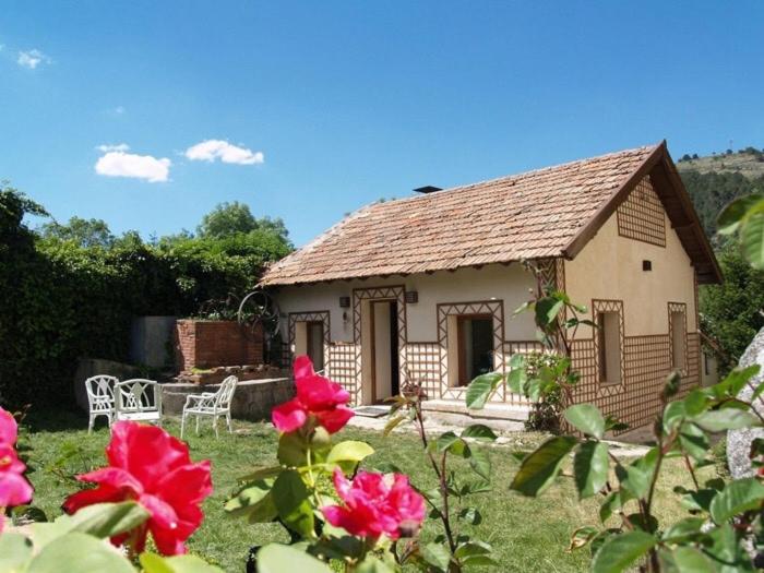 ein kleines Haus mit roten Blumen davor in der Unterkunft Casita en Finca Villa Ángeles, San Rafael in San Rafael