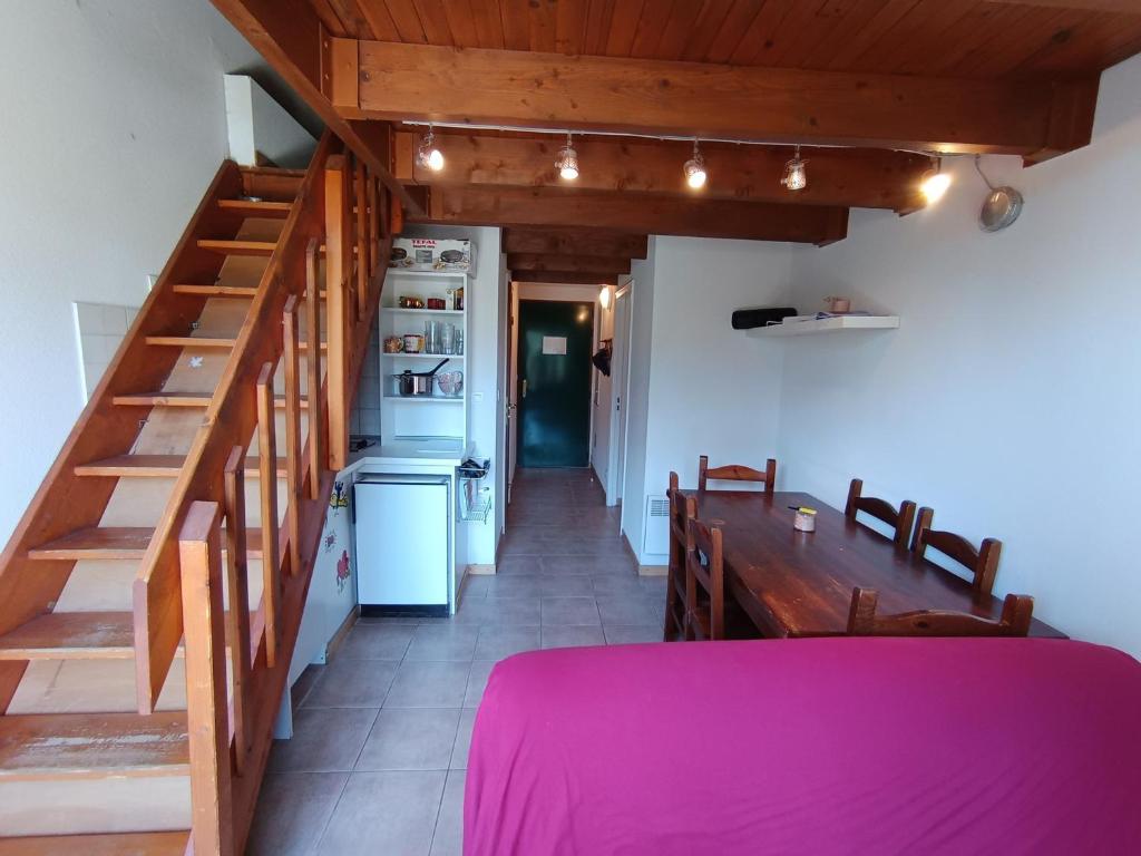 ein Raum mit einer Treppe und einem Tisch und einer Küche in der Unterkunft Duplex 4 pers. au calme avec parking, vue imprenable - FR-1-445-227 in Montgenèvre