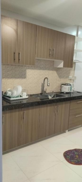 a kitchen with wooden cabinets and a sink at LV Residences Siargao in Dapa