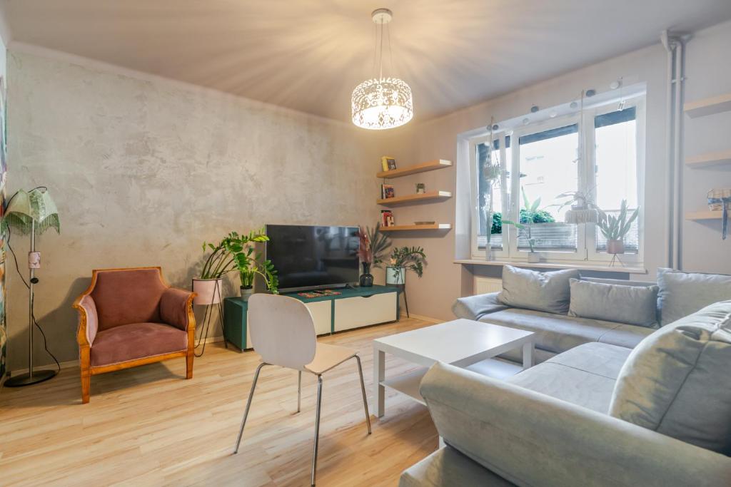 a living room with a couch and a tv at Sosnowiec Victory Apartment by BookingHost in Sosnowiec