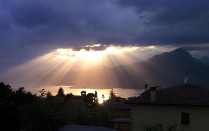 una vista del sol brillando a través de un cielo nublado en Albergo Centrale, en San Zeno di Montagna