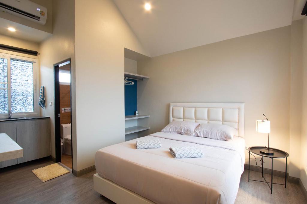 Ban Bua Phutにあるบ้านอิ่มสุขの大きな白いベッドと枕が2つある寝室