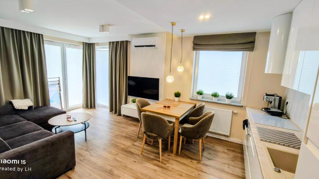 a living room with a couch and a table at Baltic Breeze Apartamenty in Kołobrzeg