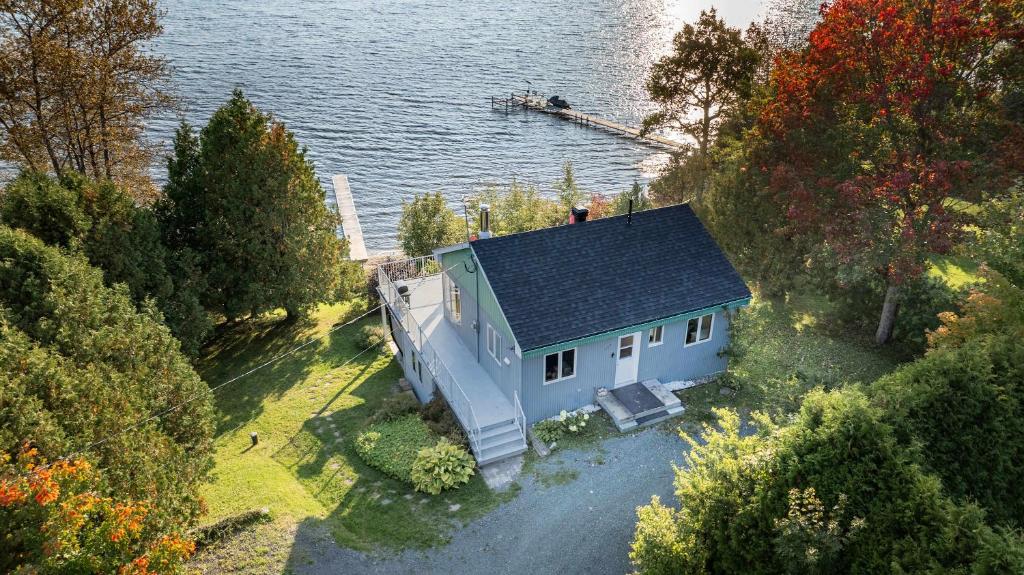 an aerial view of a blue house on the water at SPA and Lake - Chalet le Relaxarium in Sainte-Germaine-du-Lac-Etchemin
