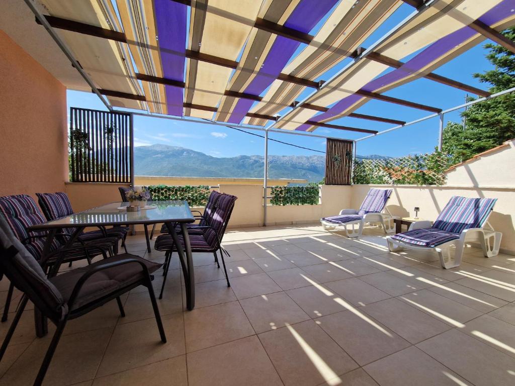 a patio with a table and chairs and a view at VILLAGE apartment in Zagvozd