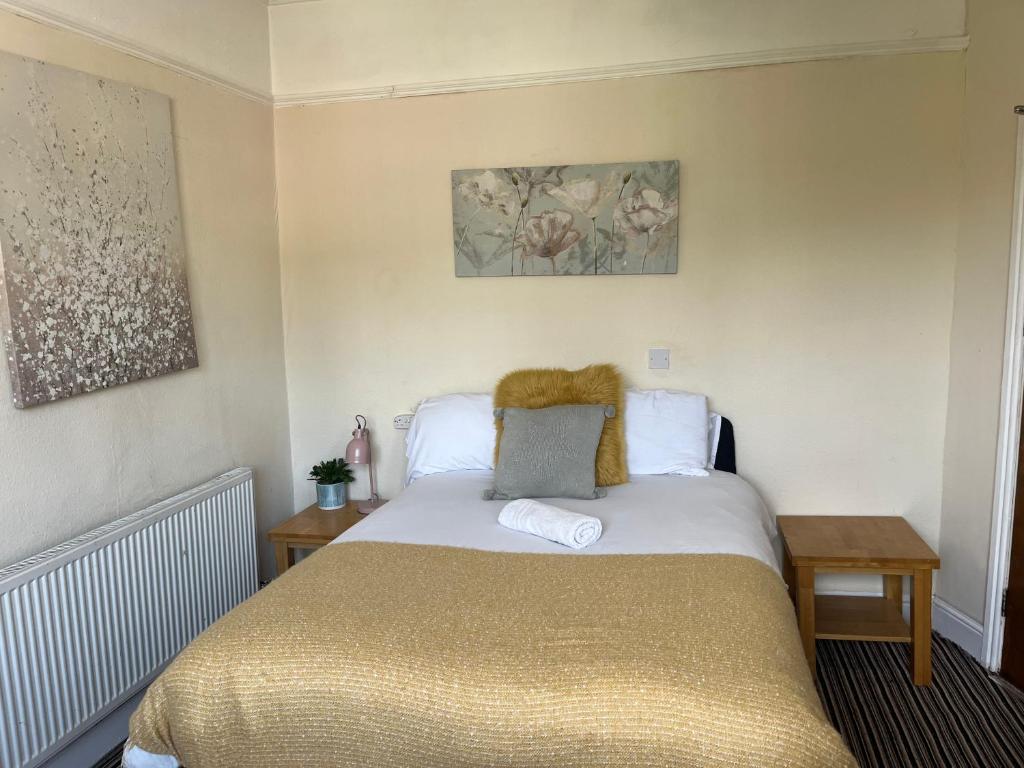 a bedroom with a bed with a gold bedspread at 101 - Room 5 - Uplands in Sketty
