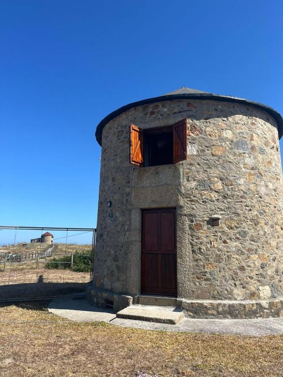 a stone building with a door and a window at In Apúlia - Moinho do Mar in Apúlia