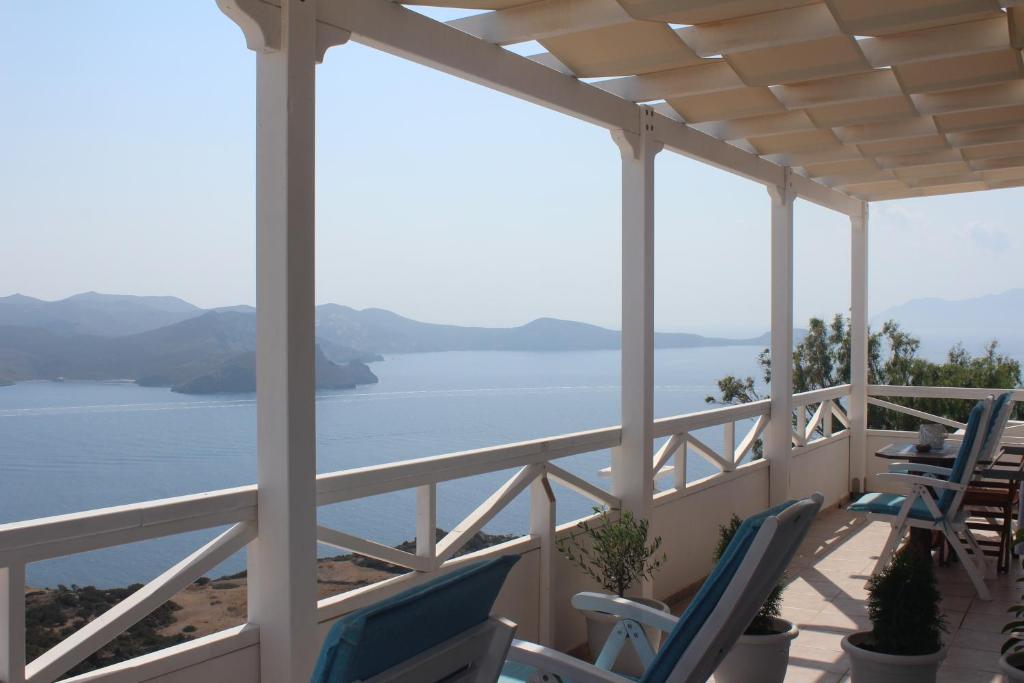 a porch with chairs and a view of the water at Studios Betty in Plaka Milou