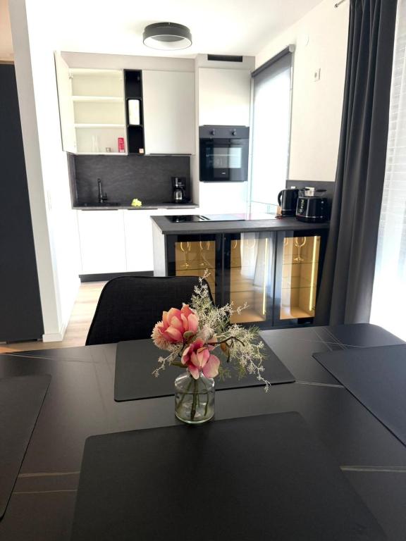 a vase with flowers on a table in a kitchen at Geisfelder Suites , Zuhause auf Zeit in Bamberg