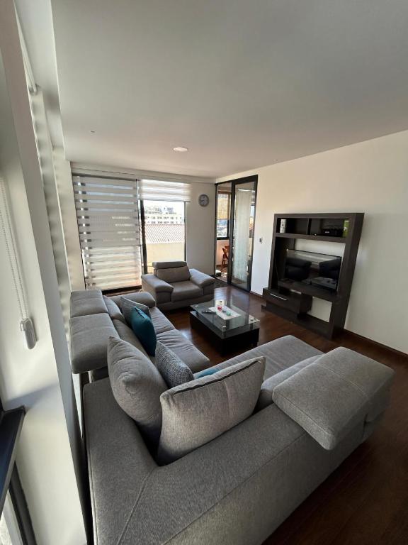 a living room with a couch and a fireplace at Amplio, Familiar y Acogedor in Cochabamba