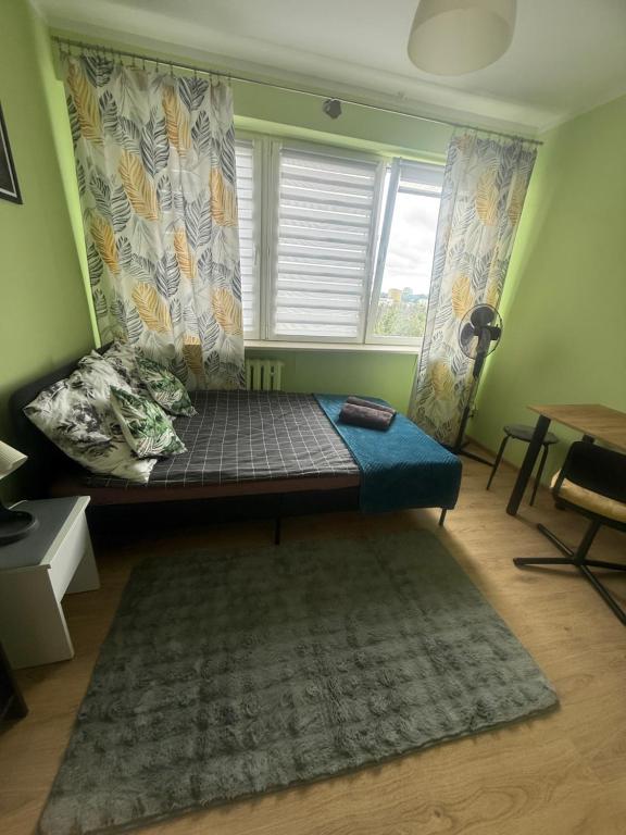 a bed in a room with a window and a rug at ClickOnTheCozyLime room pokoje Czechów in Lublin