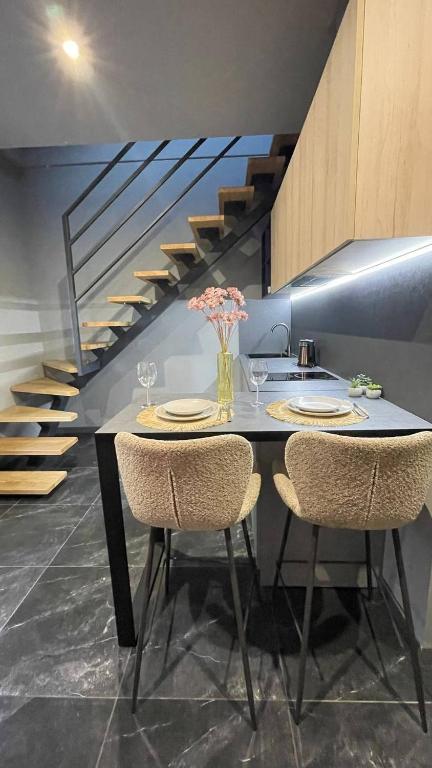 a dining room table with two chairs and a staircase at Двох рівнях апартамент для 3 осіб N1 in Chernivtsi