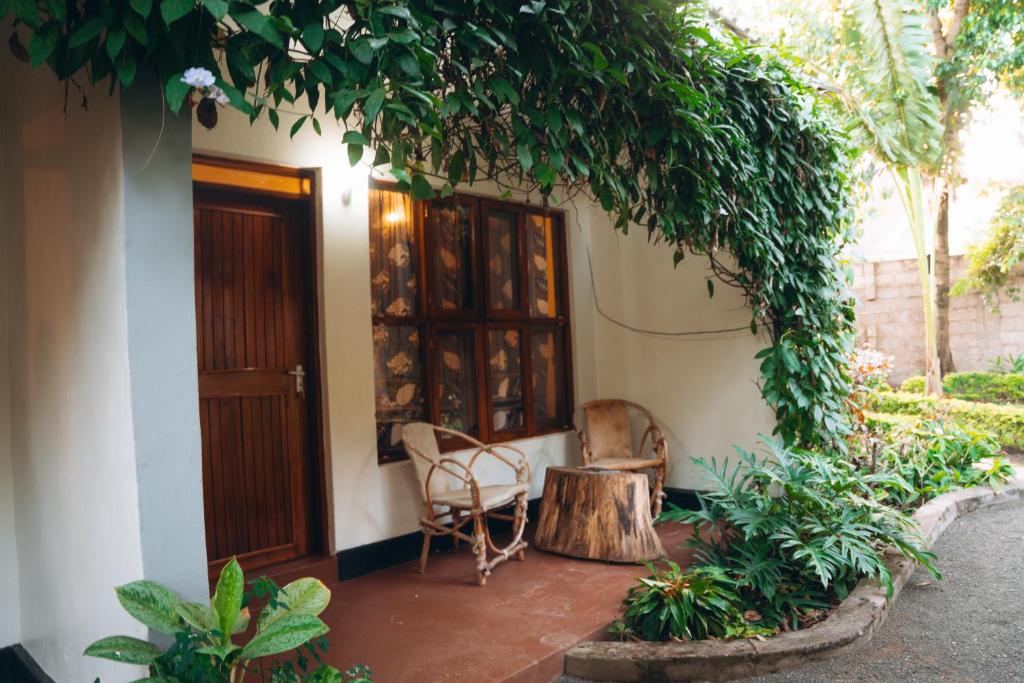 a porch of a house with a table and chairs at Kwetu Villa in Arusha