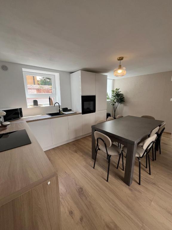 a kitchen and dining room with a table and chairs at Maison cosy - salle de jeux, cinéma et jacuzzi in Ittenheim
