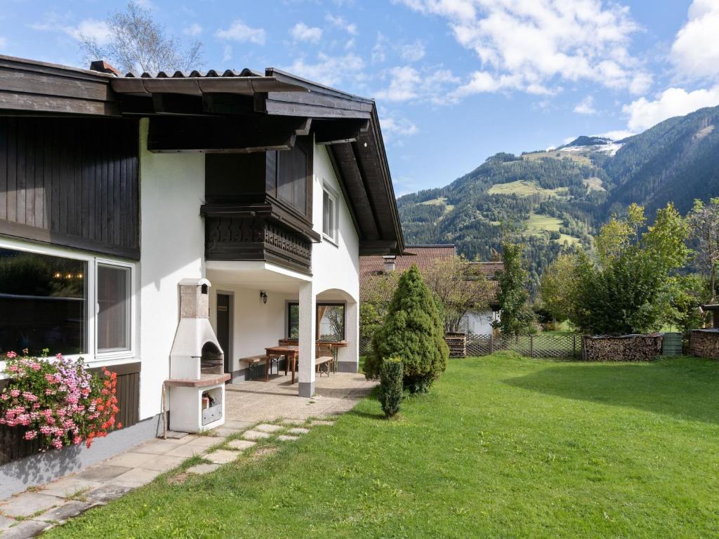 a house with a green yard with a view of mountains at Chalet in Maishofen near Ski Slopes in Maishofen