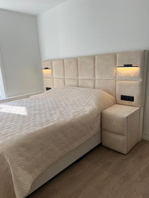 a bedroom with a large bed with two lights at Zandvoort Boutique Apartments in Zandvoort