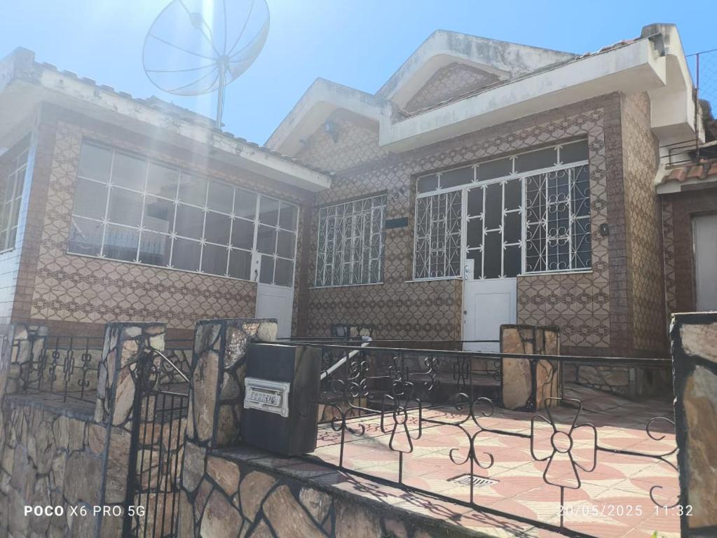 a building with a fence in front of it at Casa aconchegante em BQ in Barbacena