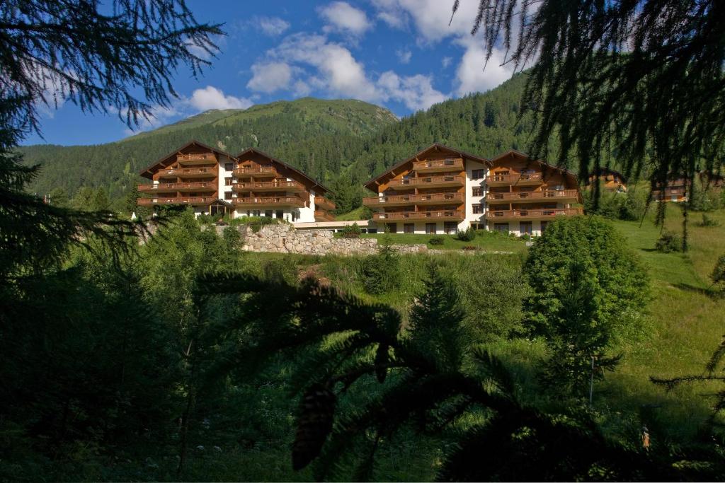 a group of wooden buildings with mountains in the background at Apartments Castle in Blitzingen