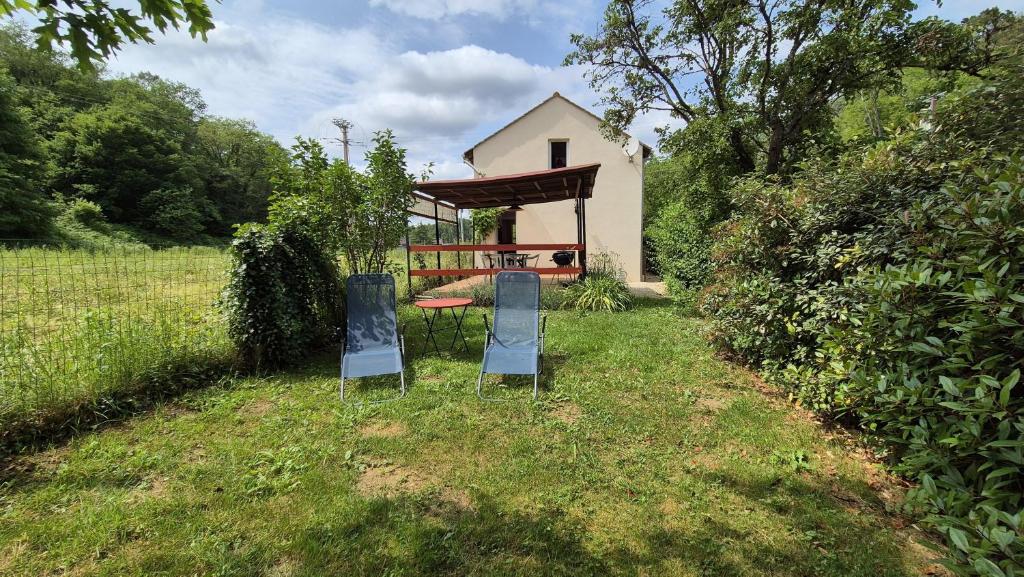 dos sillas y una mesa en el patio de una casa en Gîte La Salamandre au Sud de Sarlat, en Groléjac