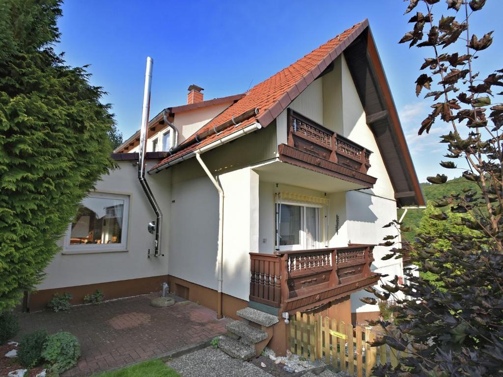 a white house with a porch and a balcony at Gruppen- Ferienhaus in Wieda in Wieda