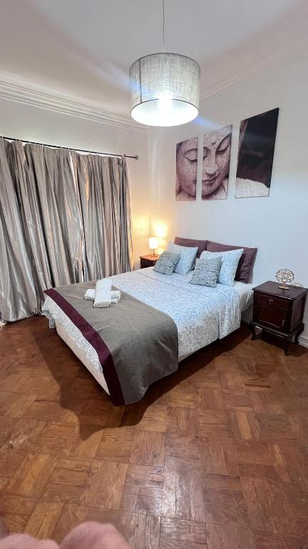 a bedroom with a large bed and a chandelier at airport room in Lisbon