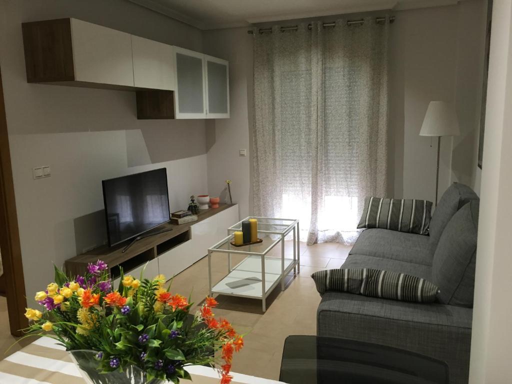 sala de estar con sofá y TV en Casa Candelaria, en Benidorm