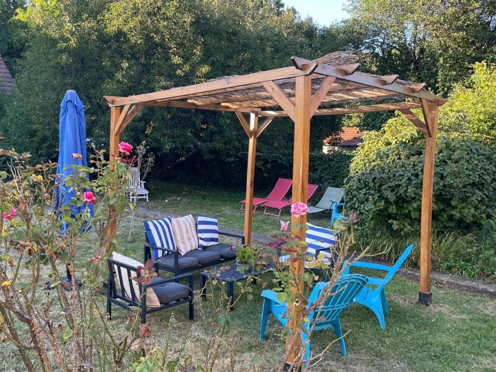 a wooden gazebo with chairs and a table in a yard at Chambre - Maison La Libéllule in Besançon