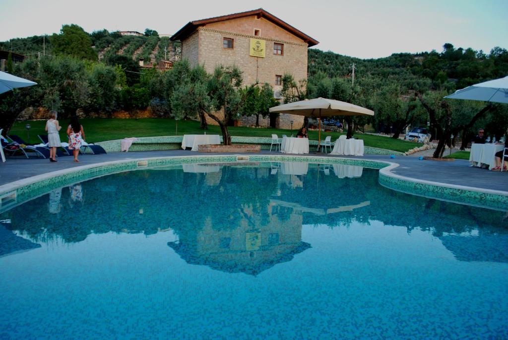 a swimming pool with blue water in front of a house at Agriturismo Casale Ré in Sonnino