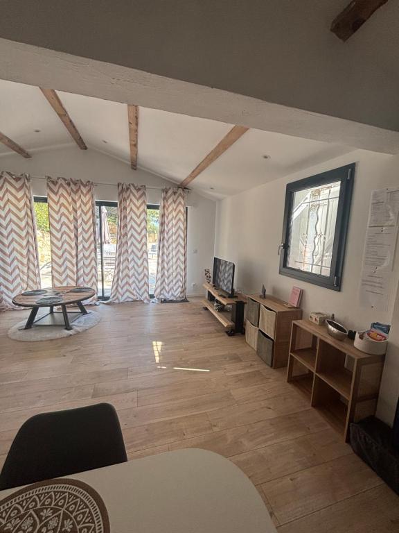 a large living room with a table and windows at Location moderne plein pied Sanary sur mer 4 pers max Léchappée belle 7 minutes en voiture du centre ville port marché et plages grand espace extérieur parking gratuit in Sanary-sur-Mer