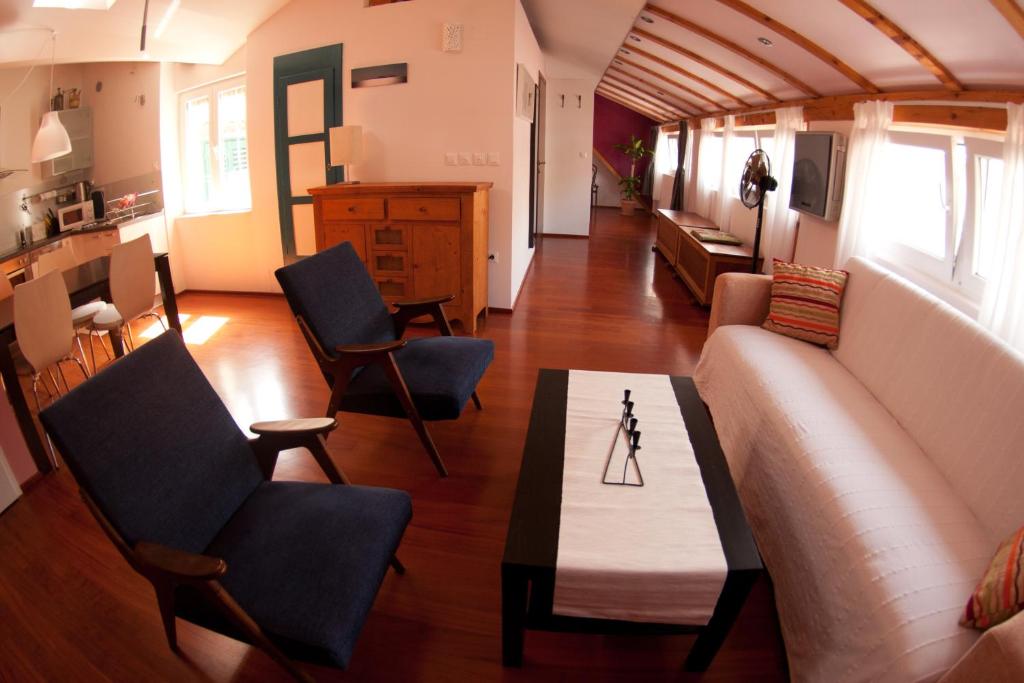uma sala de estar com um sofá e uma mesa em Sweet Loft em Split