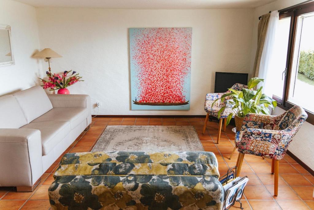 a living room with a couch and a large painting at Casa Leyian - Brissago in Brissago