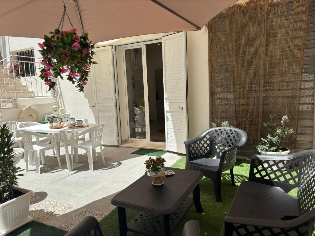 a patio with tables and chairs and a table with a chandelier at Corte Antica Marsala in Marsala
