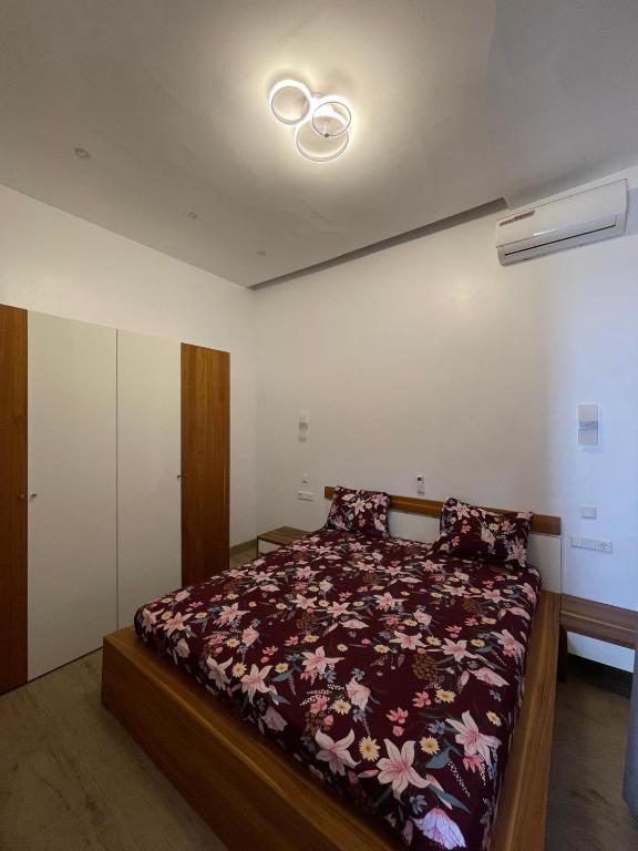 a bedroom with a bed with a floral comforter at Keur Moussa in Dakar