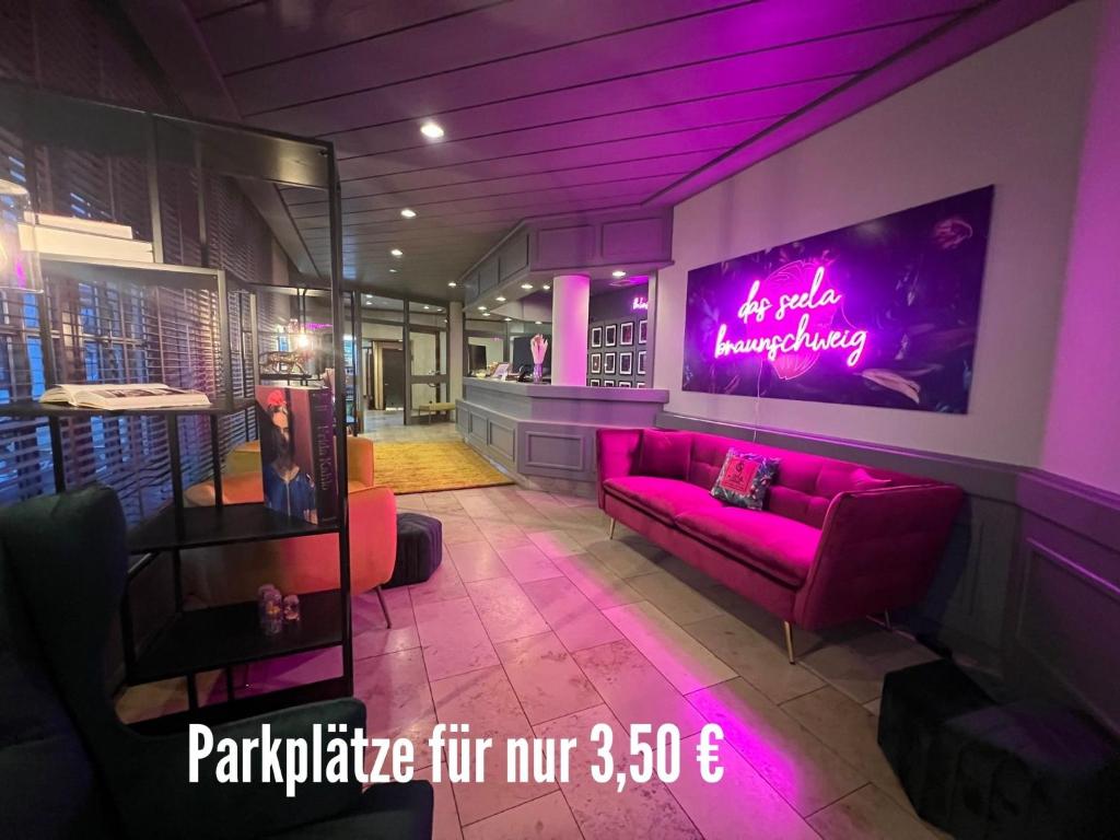 a living room with purple lighting and a couch at Das Seela Braunschweig in Braunschweig