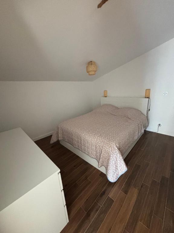 a bedroom with a bed and a wooden floor at Studio proche de Jonzac in La Celle-sous-Gouzon