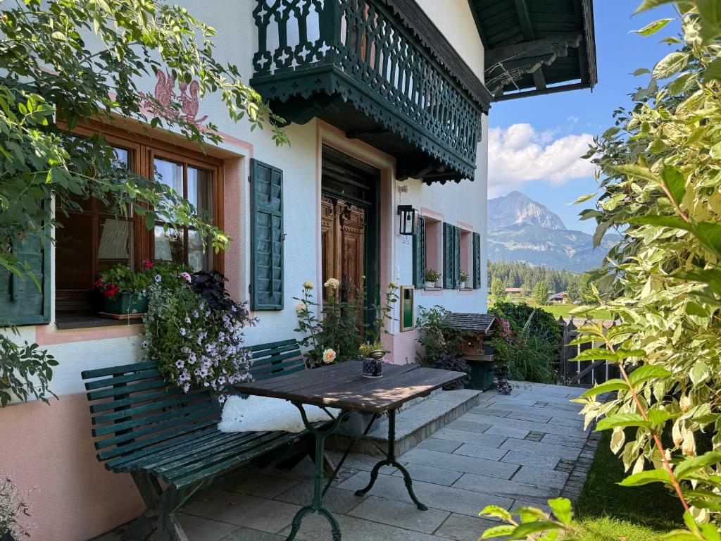 a bench sitting outside of a building with a balcony at TONIS cozy Boutique Chalet by ALPIN CHARME APARTMENTS in Reith bei Kitzbühel