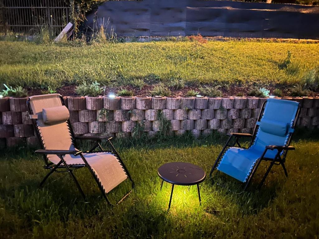 three chairs and a table in the grass at Villetta dei pini in Canzo