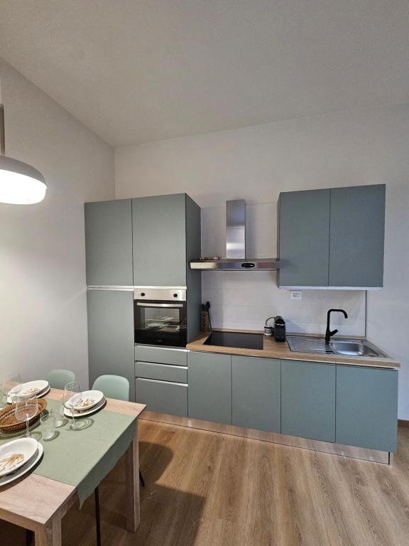 een keuken met blauwe kasten en een tafel en een tafel bij Loft Fossati in La Spezia