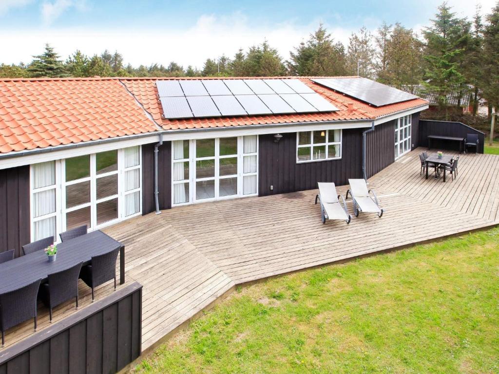 a house with a wooden deck with a table and chairs at Luxury Retreat with Pool - By Traum Ferienwohnungen in Grønhøj