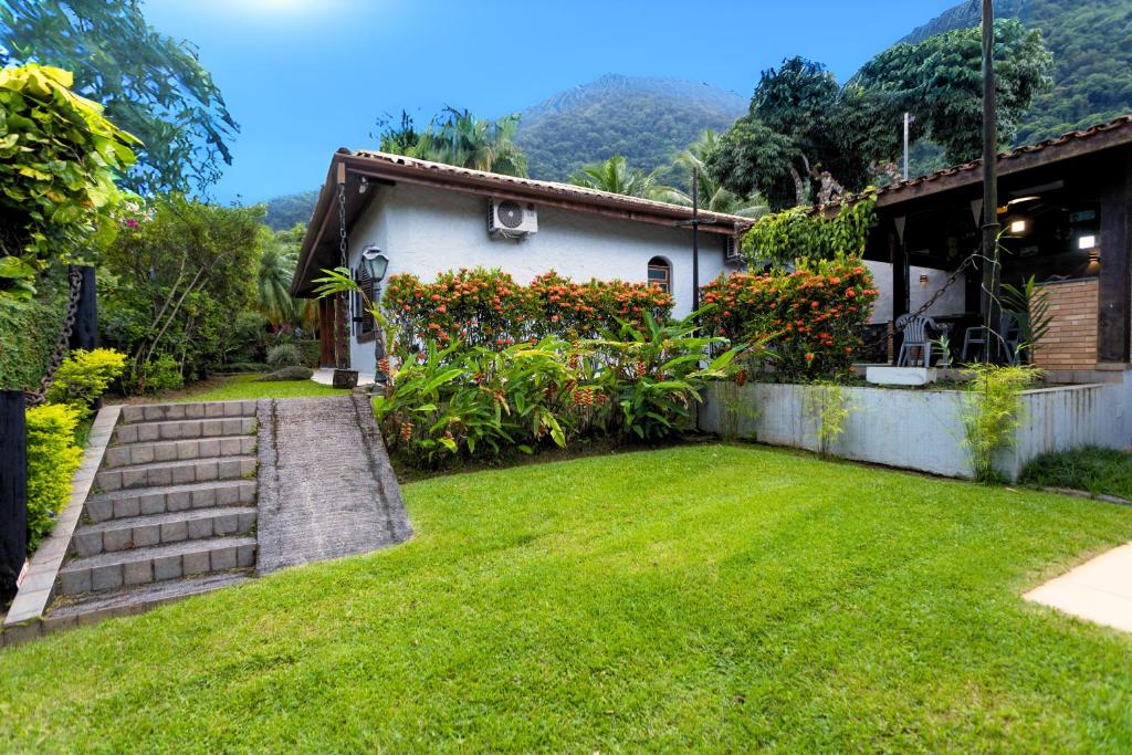 ein Haus mit einem Garten mit grünem Gras in der Unterkunft 300m da praia, AC, churrasqueira| Brazilian Corner in Toque Toque Grande