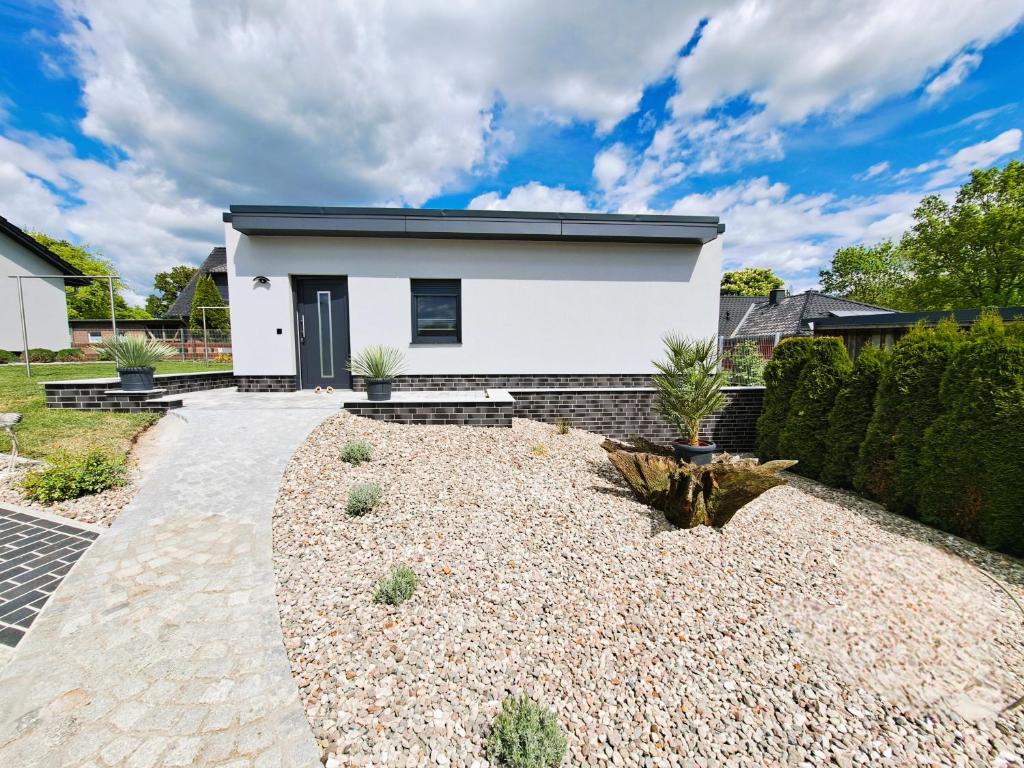 a white house with a gravel driveway at Ferienhaus "Laila" ID 16019-2 in Möllenhagen