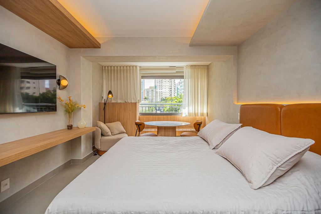 Un dormitorio con una cama grande y una mesa. en Flat c Piscina e Academia na Chacara Klabin, en São Paulo