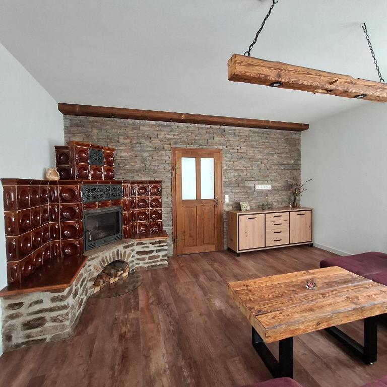 a living room with a brick fireplace and a table at Kleine Auszeit Im Alten Huthaus in Brand-Erbisdorf