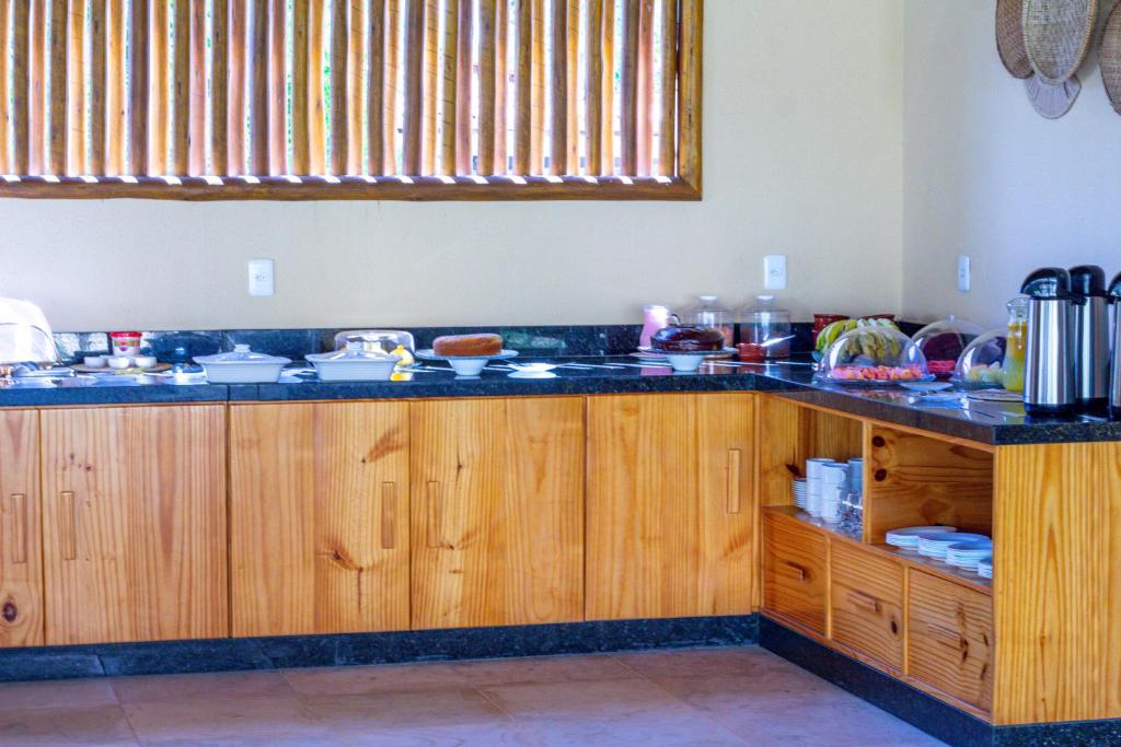 a kitchen with wooden cabinets and a counter top at Vila Preá in Prea