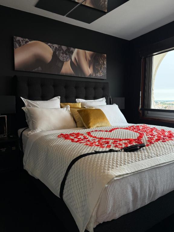 a bedroom with a large bed with red flowers on it at Love Horizons - Suite vue panoramique - Spa privatif - Rennes Centre in Rennes